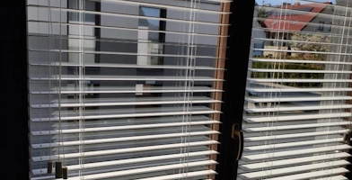 Zdjęcie przedstawiające żaluzje drewniane 50mm zamontowane na oknach